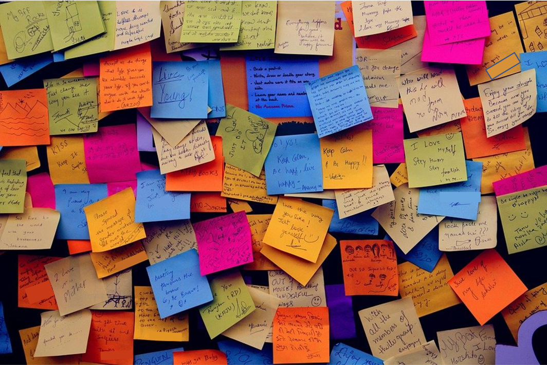 A crowded wall of Post-it notes with lots of different inspirational messages included