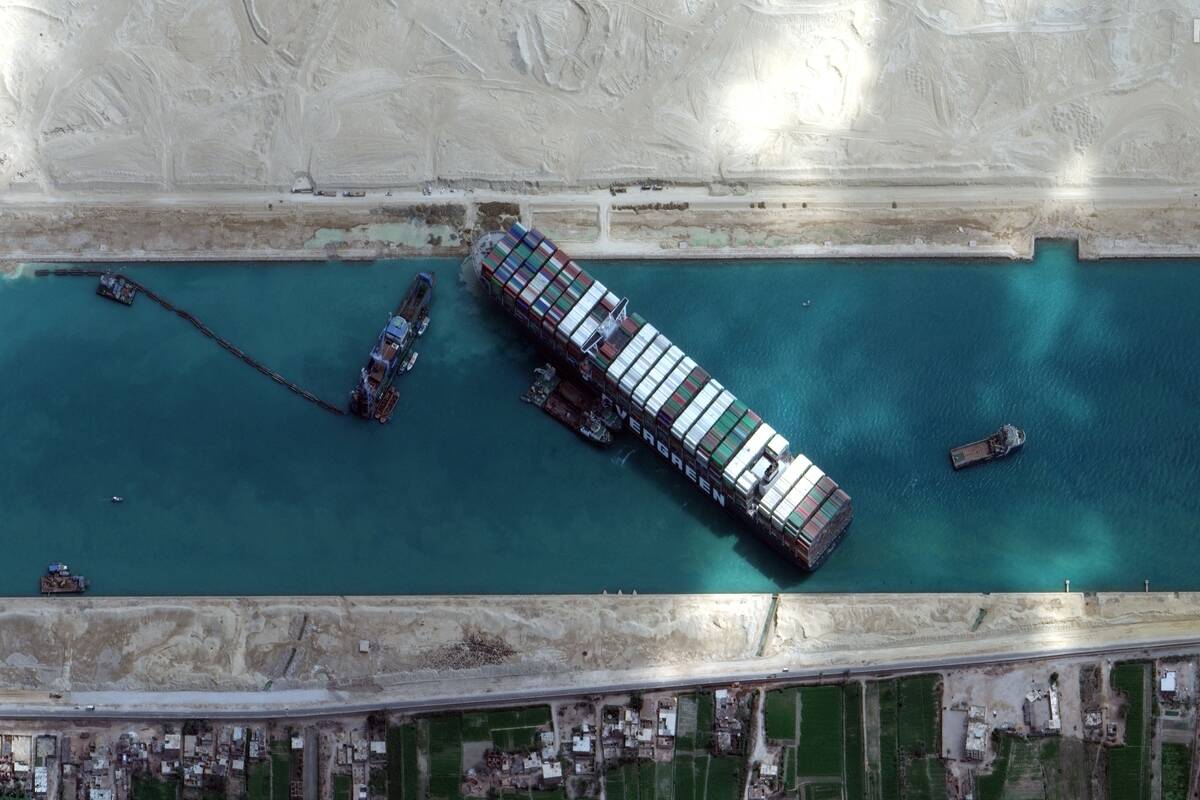 An aerial view of the Ever Given cargo ship stuck across the entire width of the Suez Canal