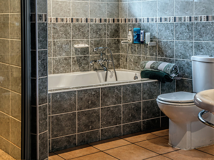 A bathroom with tiles on the walls, floor and bath enclosure